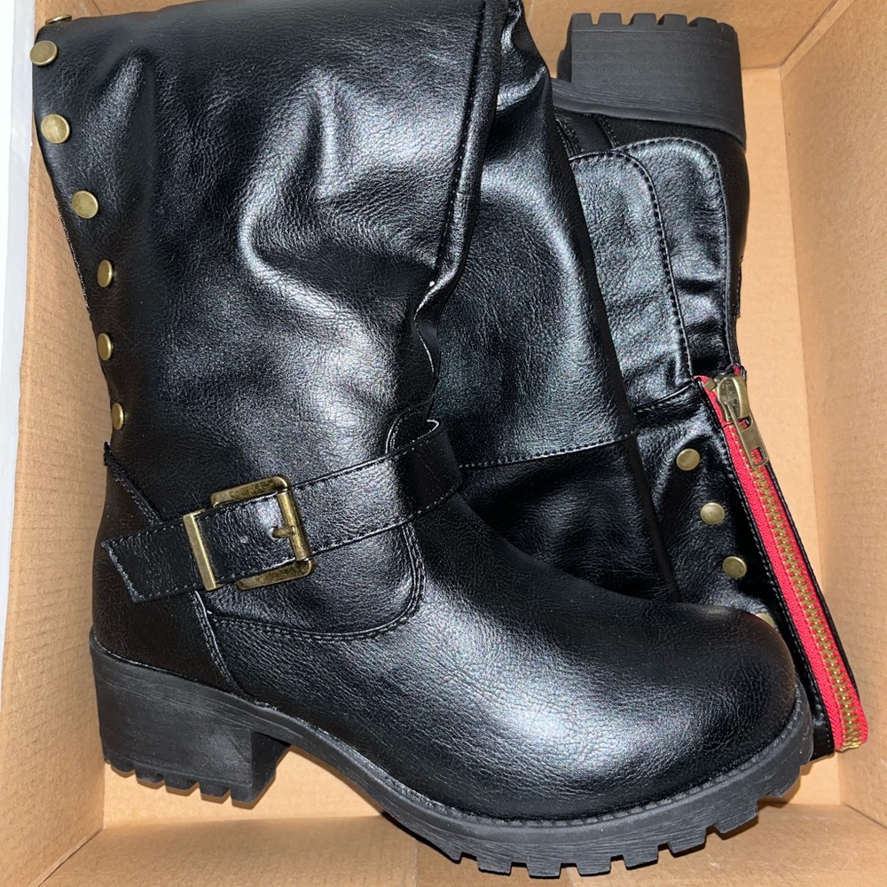 Knee high black combat boots .